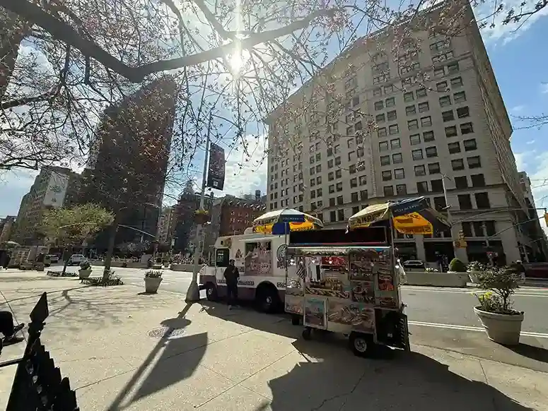 New York City Weather in July: Street food vendor with the Flatiron Building in the background.